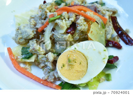 boiled egg half cutting topping sour and spicy minced pork salad on plate 70924001