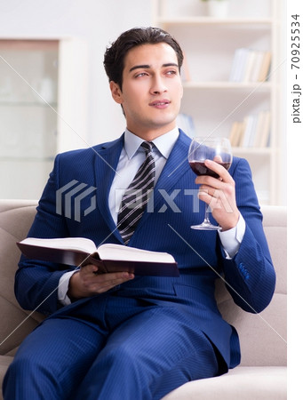 Businessman drinking wine sitting at home 70925534