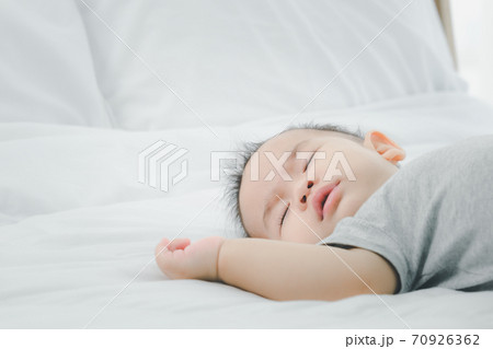 Cute 7 months asian baby girl is sleeping on bed in the morning.Newborn little child sleep have nice dream. 70926362