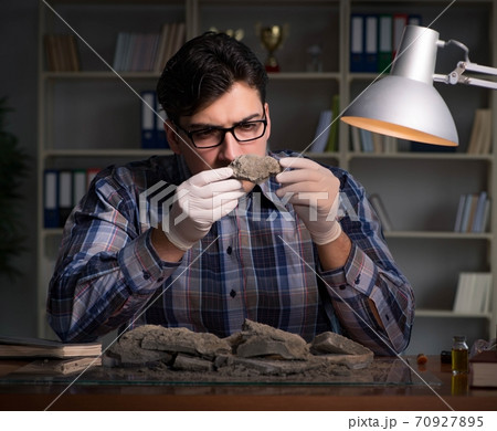 Archeologist working late night in office 70927895