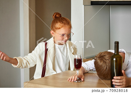 young kids couple at home, boy is drinking alcohol young kids couple at home, boy is drinking alcohol 70928018