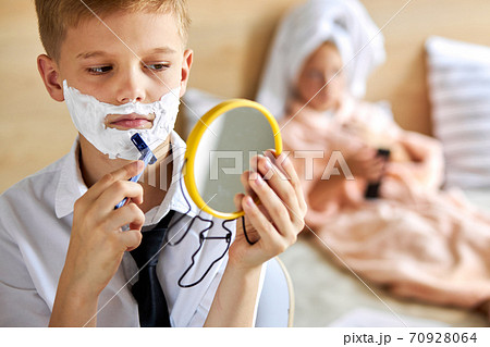 close-up portrait of child boy shaving beard close-up portrait of child boy shaving beard 70928064