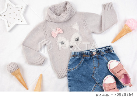 Set of casual child clothes, shoes and accessories on white background. Fashion girl lookbook consept. Knitted sweater, denim skirt, sneakers, ice cream cone. Top view, flat lay Closeup 70928264