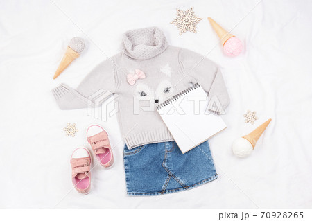 Set of casual child clothes, shoes, accessories and open notepad on white background. Fashion girl lookbook consept. Knitted sweater, denim skirt, sneakers, ice cream cone. Top view, flat lay Mockup Set of casual child clothes, shoes, accessories and open notepad on white background. Fashion girl lookbook consept. Knitted sweater, denim skirt, sneakers, ice cream cone. Top view, flat lay Mockup 70928265