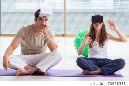 Man and woman with VR glasses meditating Man and woman with VR glasses meditating 70928588