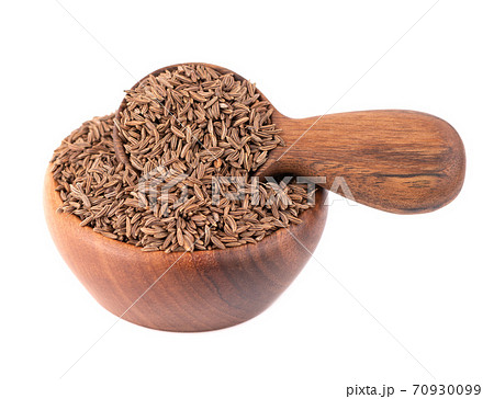 Cumin seeds in wooden bowl and spoon, isolated on white background. Cumin seeds or caraway. Cumin seeds in wooden bowl and spoon, isolated on white background. Cumin seeds or caraway. 70930099