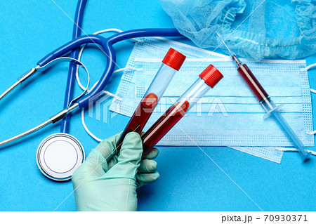 lab technician assistant or doctor holding a blood sample in test tube at laboratory 70930371
