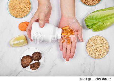 Vitamin nutrition pills on hand, Natural mineral medicine supplement from organic fruit 70930617