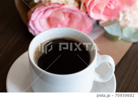 A cup of black hot coffee and a lovely bouquet of roses 70930682
