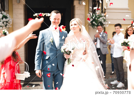 Guests Throwing Confetti Over Bride And Groom At Wedding Guests Throwing Confetti Over Bride And Groom At Wedding 70930778