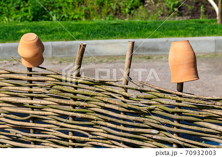 Clay jugs on a wooden wicker fence. Traditional ukrainian rural decor 70932003