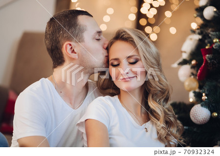 Loving boyfriend kissing girlfriend near Christmas 70932324