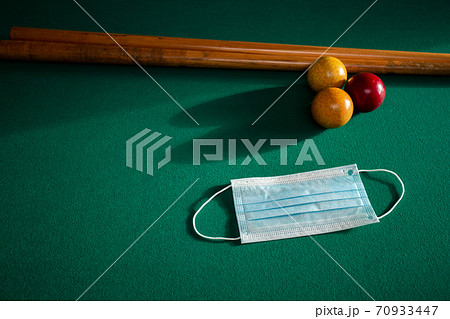 Blue medical face mask for Coronavirus on a green billiard table, protective medical mask for Covid-19 on pool,snooker table 70933447