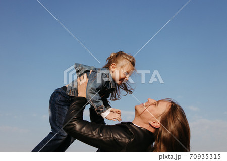 Cheerful father playing with little daughter outdoors 70935315