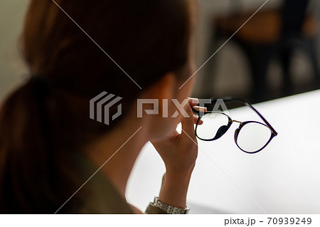 メガネを外す女性のしぐさの写真素材
