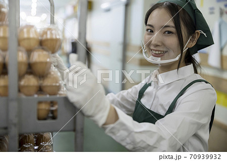 スーパーのバックヤードでマウスシールドをして作業をする女性従業員 スーパーのバックヤードでマウスシールドをして作業をする女性従業員 70939932