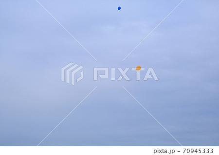 空に飛んでいく二つの風船 70945333