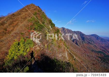 鳥甲山の尾根に立つ登山者の影 70945489