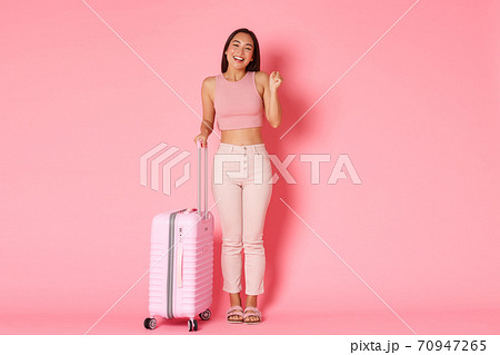 Travelling, holidays and vacation concept. Full-length of cheerful smiling asian girl finally going abroad after coronavirus pandemic, standing with suitcase and rejoicing 70947265