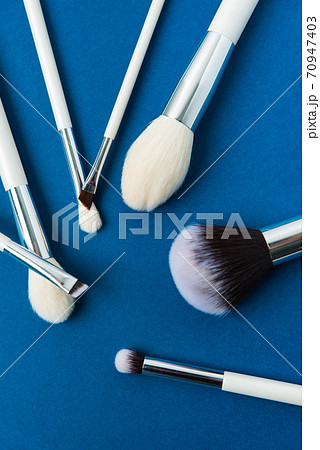 makeup brushes with a white handle on a blue background makeup brushes with a white handle on a blue background 70947403
