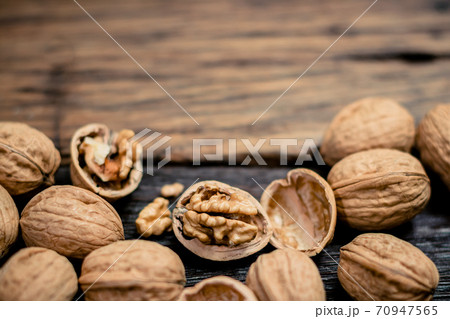still life with Walnut kernels and whole walnuts on rustic old wooden table still life with Walnut kernels and whole walnuts on rustic old wooden table 70947565