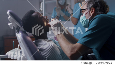Dentist checking teeth of black patient Dentist checking teeth of black patient 70947953