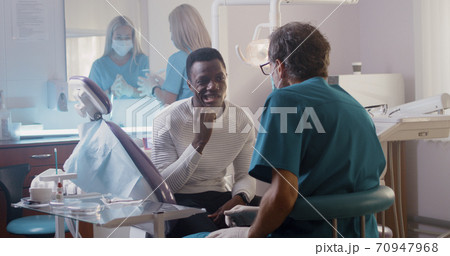 Dentist and client talking in hospital office Dentist and client talking in hospital office 70947968