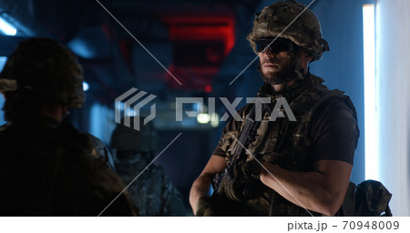 Male commander with gun giving orders to SWAT team 70948009