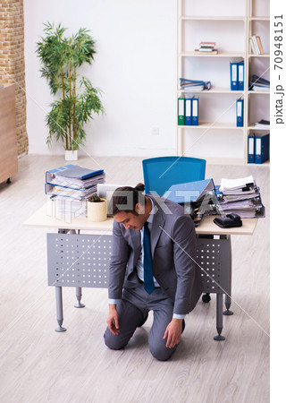 Young male employee unhappy with excessive work 70948151