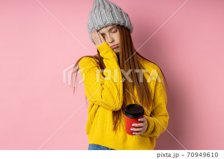 Redhead woman holding disposable cup of coffee 70949610