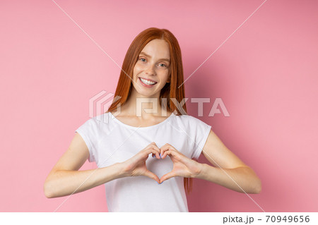 Portrait of young happy redhead woman in white t shirt 70949656