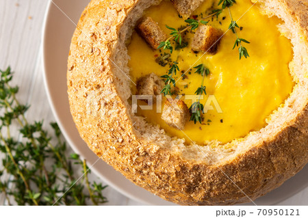 Pumpkin puree soup in a plate of bread 70950121