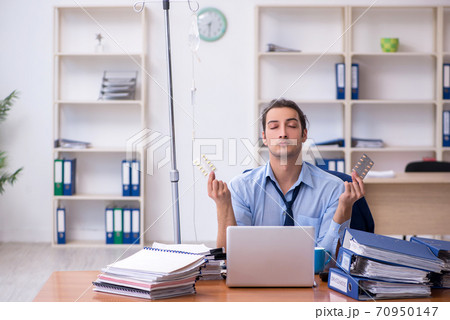 Young male employee suffering at workplace Young male employee suffering at workplace 70950147