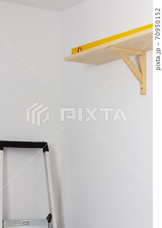 The process of attaching a wooden shelf to the wall The process of attaching a wooden shelf to the wall 70950152