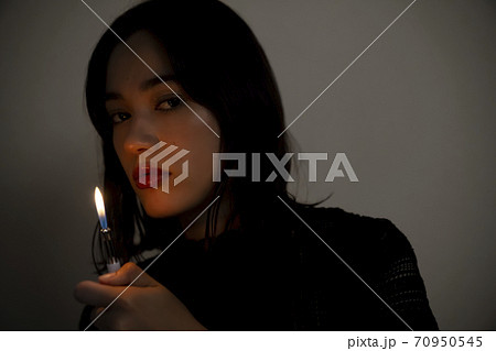 ライターを持つ女性のポートレート 70950545