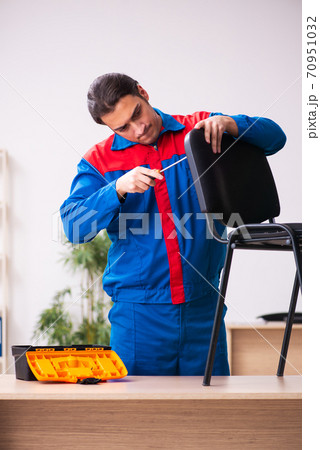 Young male contractor repairing furniture in the office 70951032