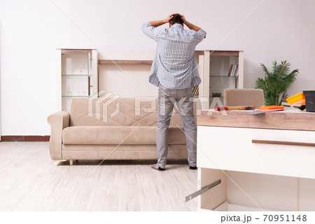 Young male carpenter repairing furniture at home 70951148