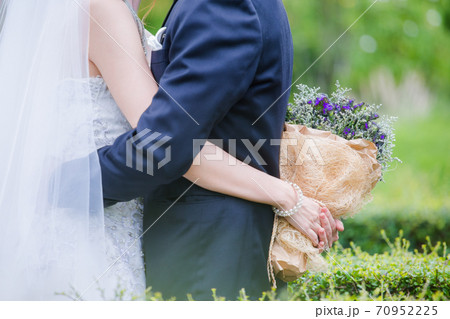 Newlyweds with a bouquet of beautiful flowers 70952225