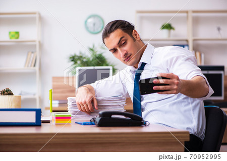 Young male employee working in the office 70952995