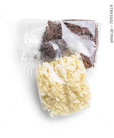 Grated white and dark chocolate. Chocolate flakes in plastic bags isolated on white background. Grated white and dark chocolate. Chocolate flakes in plastic bags isolated on white background. 70954814