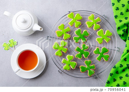 Shamrock cookies on cooling rack with cup of tea, St. Patrick's Day dessert. Grey background. 70956041
