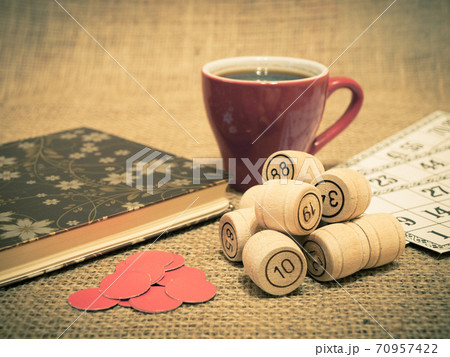 Wooden lotto barrels, cards, chips and cup of coffee on sackcloth. Wooden lotto barrels, cards, chips and cup of coffee on sackcloth. 70957422