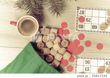 Wooden lotto barrels with bag, game cards, red chips and cup of coffee Wooden lotto barrels with bag, game cards, red chips and cup of coffee 70957545