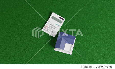 平面上に置かれたおもちゃの住宅と電卓 70957570