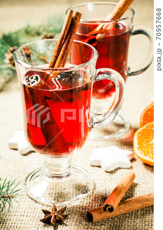 Glass of Christmas mulled wine with spices, orange and cookies on sackcloth Glass of Christmas mulled wine with spices, orange and cookies on sackcloth 70957668