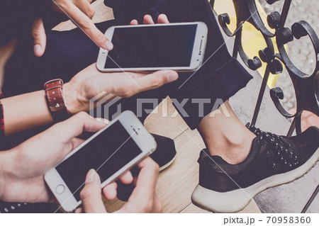 Close up of men and  woman hands holding touching mobile phone 70958360
