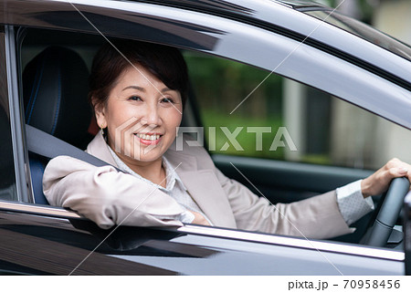 車を運転するスーツ姿の女性の写真素材