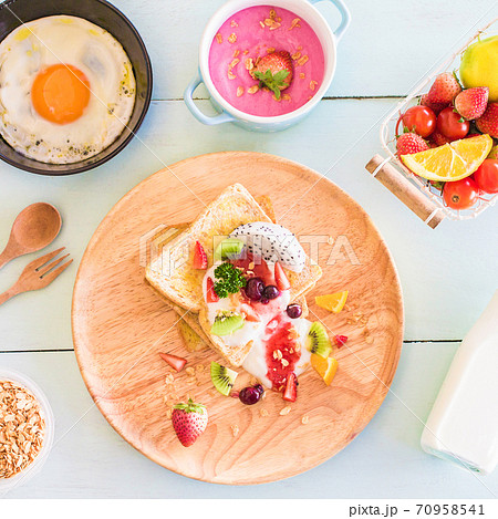 Toast and fruit total milk yogurt with fried egg in a frying pan on wood Toast and fruit total milk yogurt with fried egg in a frying pan on wood 70958541