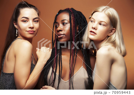 young pretty asian, caucasian, afro woman posing cheerful together on brown background, lifestyle diverse nationality people concept young pretty asian, caucasian, afro woman posing cheerful together on brown background, lifestyle diverse nationality people concept 70959443