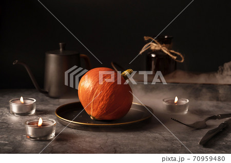 Vintage template with old metal tableware, ripe pumpkin and ear of wheat on black stone background for concept design. Fall concept. Vintage template with old metal tableware, ripe pumpkin and ear of wheat on black stone background for concept design. Fall concept. 70959480